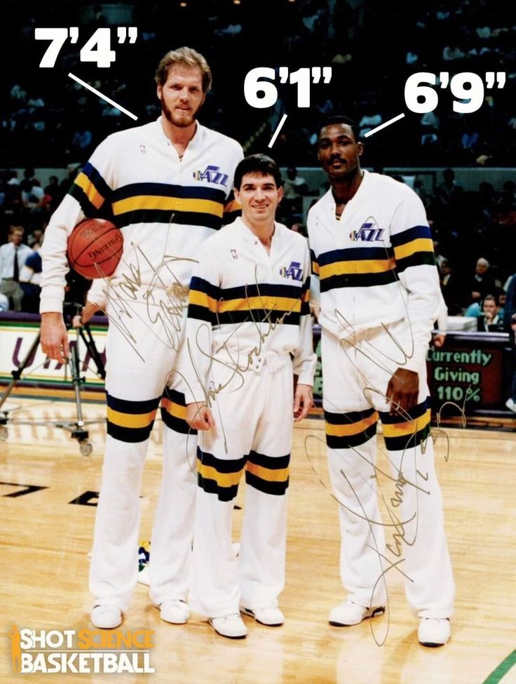 three basketball players posing for a photo in front of the court with their autographs