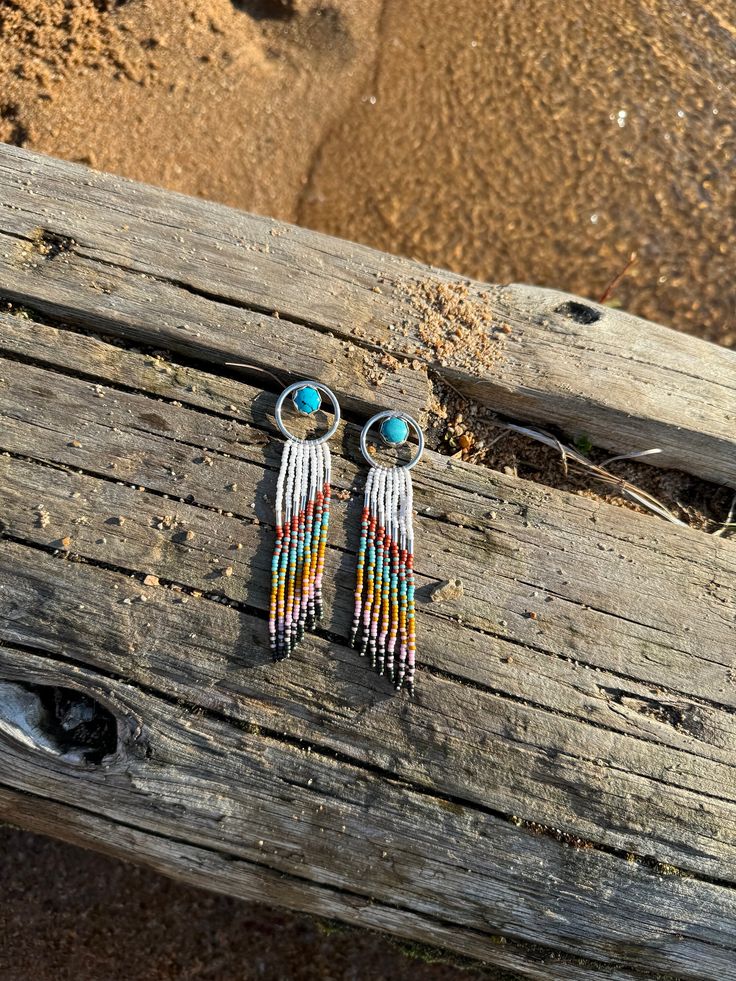 These Halo earrings are among my favorites. They feature Kingman Turquoise set in scalloped fine silver with a sterling hoop. These are handmade from raw silver in my studio, then hand beaded by me, bead by bead. These also feature sterling silver tube beads.  Photographed at Priest Lake in Northern Idaho.  Please follow along here and on Instagram @NatPBrightsmithing All of my handmade, silver smithed jewelry  is unique. Even between earrings in a pair. There may be small imperfections and variations and these are the things that make handmade jewelry beautiful and one of a kind. I hope you love what you see. Handmade Sterling Silver Bohemian Earrings, Handmade Bohemian Sterling Silver Earrings, Turquoise Sterling Silver Jewelry With Silver Beads, Unique Sterling Silver Beaded Earrings, Southwestern Sterling Silver Jewelry For Festivals, Southwestern Beaded Round Earrings, Southwestern Style Beaded Round Earrings, Southwestern Round Beaded Earrings, Southwestern Silver Beaded Earrings