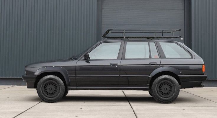 an suv parked in front of a building with a roof rack on it's top