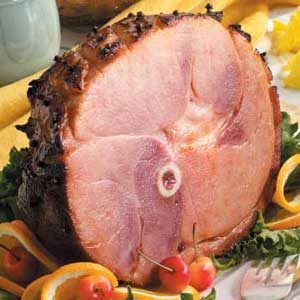 a ham is sitting on top of some pasta and other food items in front of it