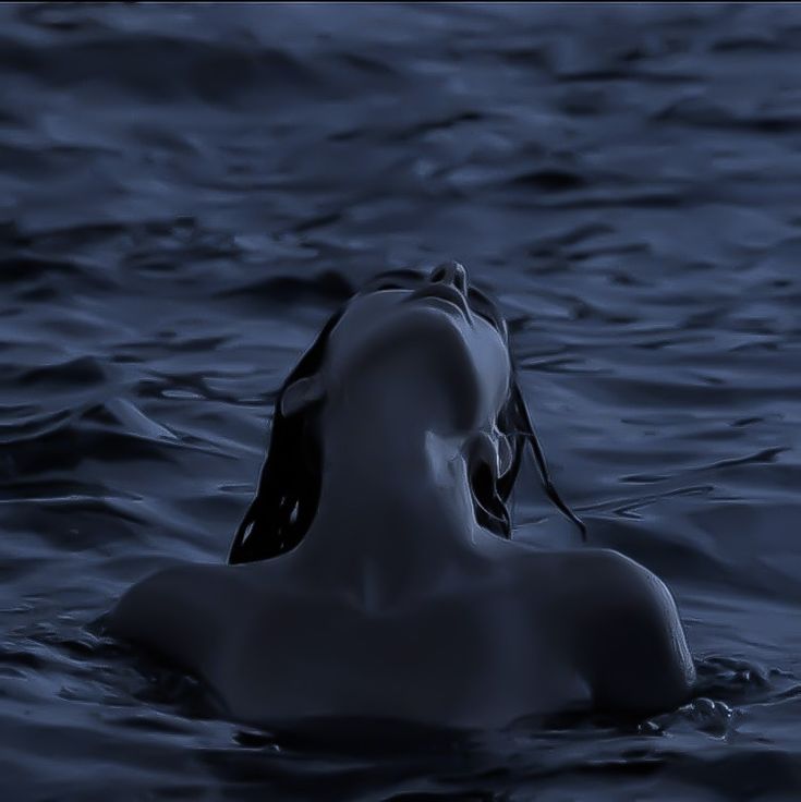 a woman floating in the water with her eyes closed