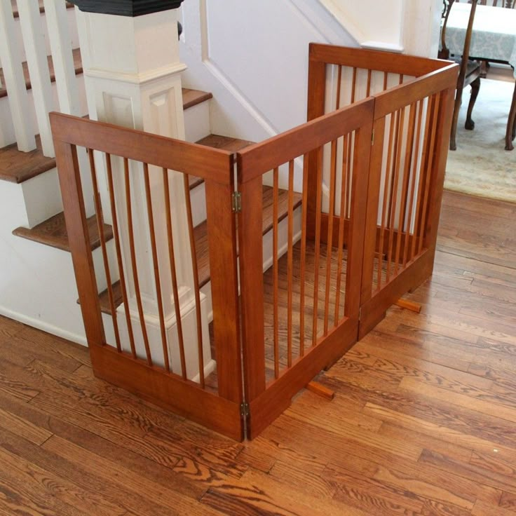 there is a baby gate in the middle of the floor next to stairs and a trash can