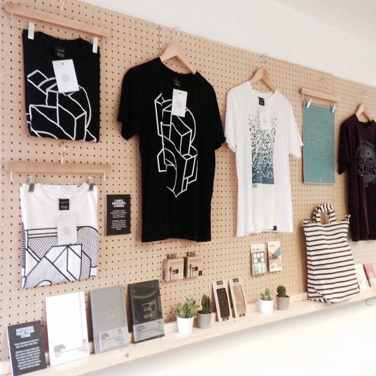 there are many t - shirts hanging on the wall in front of each other,