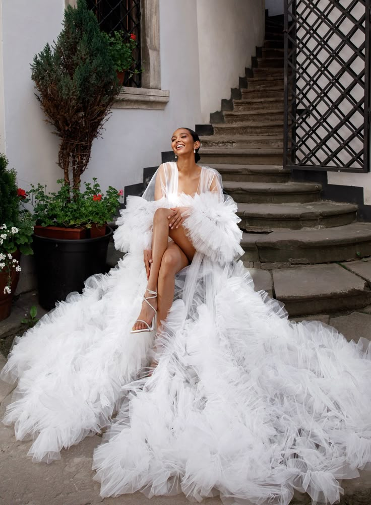 a woman in a white dress sitting on some steps