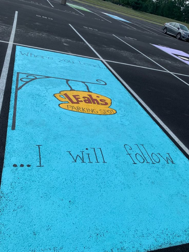 an empty parking lot with blue paint and writing on the ground that says, i will follow