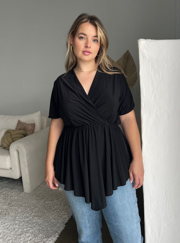 When you need a good top that will take you from work to a night out with friends, the Plus Size Drapey Surplice Blouse is the top for you. Pair this pretty dress with some cute layered necklaces and some standout pants and you're really for your 9 to 5 and beyond. This top features a tie at the back of the neck and sleeves, an elastic waist, a v-shaped hemline, and a plunging neckline. The material is a smooth, stretchy, and shiny knit. This top is made from 96% polyester and 4% spandex. Dry cl Wrap Top Plus Size, Plus Size Wrap Top, Cute Layered Necklaces, Kawaii Top Plus Size, Solid V-neck Faux Wrap Top, Plus Size Cleavage Shirts, Surplice Blouse, 9 To 5, Pretty Dress