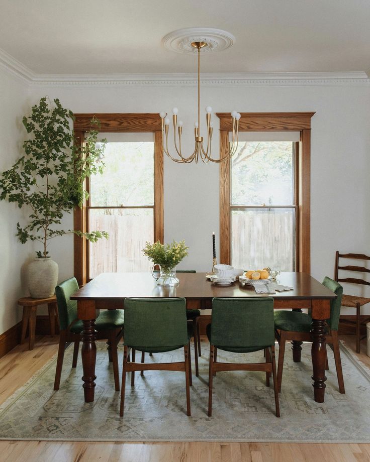 a dining room table with green chairs around it