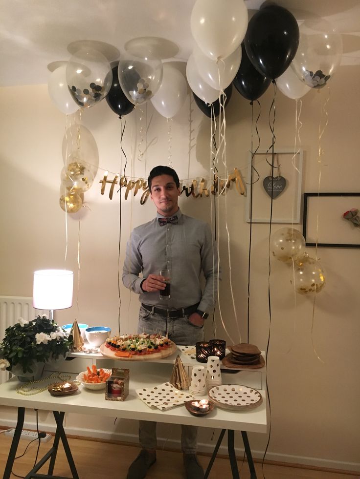 a man standing in front of a table filled with food and balloons