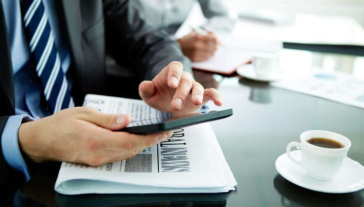 two people sitting at a table with papers and a cell phone in their hands - stock photo - images