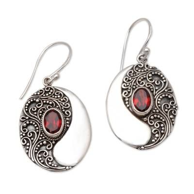 An oval pool of natural garnet is reflected in a larger oval of sterling silver. Eka Devi crafts these beautiful dangle earrings elaborating them wit traditional Balinese motifs. Ornate Oval Sterling Silver Earrings, Oval Garnet Filigree Jewelry, Bohemian Sterling Silver Oval Earrings, Bohemian Oval Sterling Silver Earrings, Oval Garnet Gemstone Earrings, Ornate Oval Earrings As Gift, Ornate Oval Earrings For Gift, Oval Garnet Jewelry With Intricate Design, Traditional Silver Oval Earrings