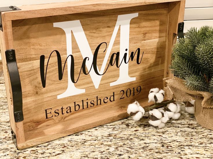 a wooden sign with cotton in front of it and a potted plant behind it