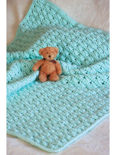 a crocheted blanket with a teddy bear on it