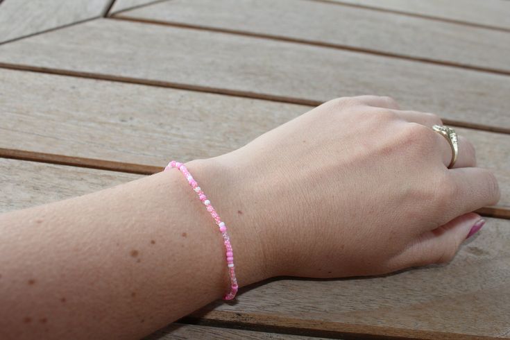 Random combination of beautiful pink and white beads make this a perfect dainty bracelet! Pink Hand-strung Friendship Bracelets With Round Beads, Pink Pearl Bracelet With Tiny Round Beads, Dainty Pink Bracelets With Faceted Beads, Handmade Dainty Pink Pearl Bracelet, Summer Pink Hand-strung Beads, Delicate Pink Pearl Bracelet With Round Beads, Delicate Pink Pearl Beaded Bracelet, Summer Hand-strung Pink Beads, Pink Round Beads Friendship Bracelets For Summer