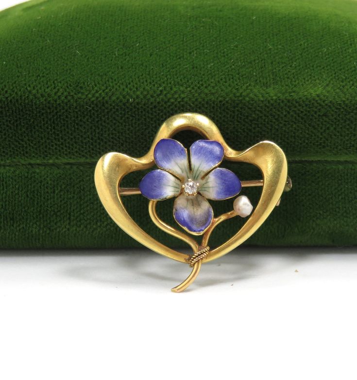 "Art Nouveau/1900 14k yellow gold hand enameling .05 carat natural diamond H in color 1\" x 1\" condition: excellent Beautiful Art Nouveau flower brooch, crafted of 14 karat yellow gold and set with hand enameling and a natural diamond.  The brooch is a nice size, measuring 1\" x 1\", and features a lavender flower delicately detailed in enamel, with a .05 carat natural diamond H in color set at the center.   The brooch is in excellent condition, with no damage to the gemstone or enamel loss.  I Yellow Gold Enamel Brooches, Diamond Flower Brooch As Gift, Diamond Flower Brooch For Gift, Elegant Yellow Gold Enamel Brooches, Elegant Flower Enamel Pin Collectible, Diamond Flower Brooches For Gifts, Art Deco Yellow Gold Collectible Brooches, Yellow Gold Enamel Brooches Hallmarked, Art Nouveau Yellow Gold Brooches Gift