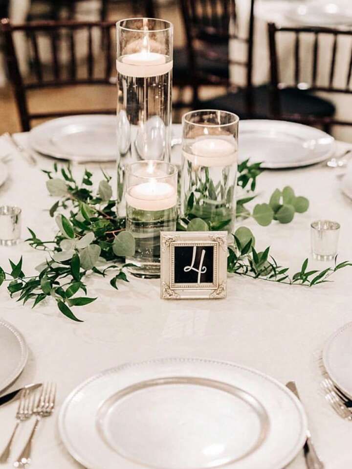 the table is set with candles, plates and silverware for an elegant wedding reception