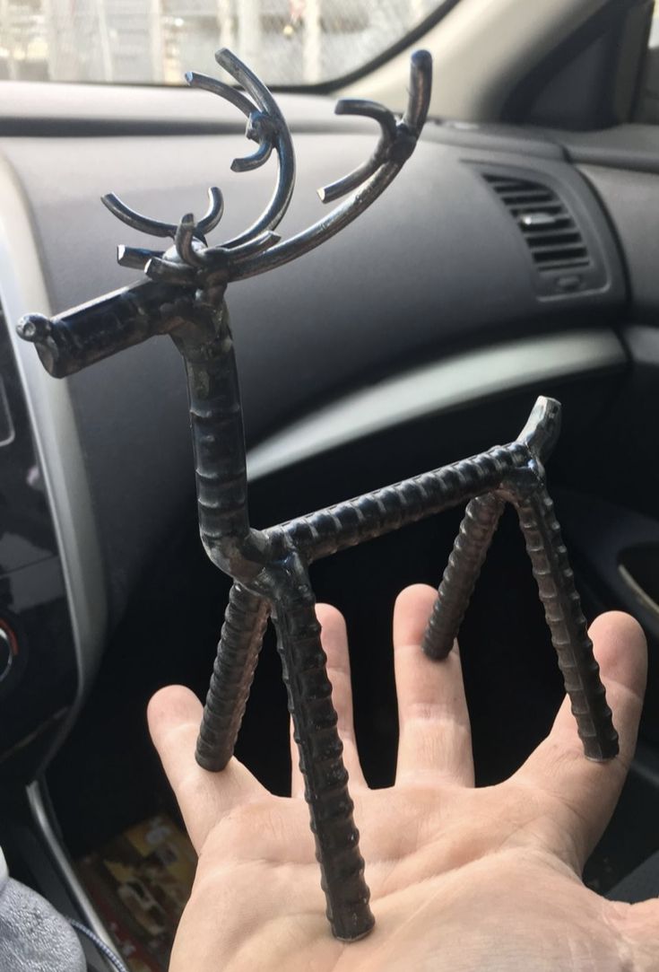 a hand holding a metal object in the middle of a car