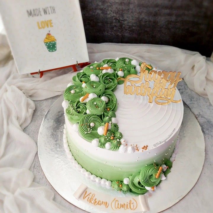 a green and white cake on a table with a happy birthday card next to it