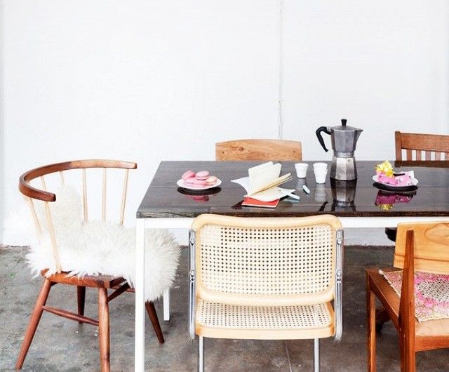 the table is set with four chairs and plates on it, along with a coffee pot