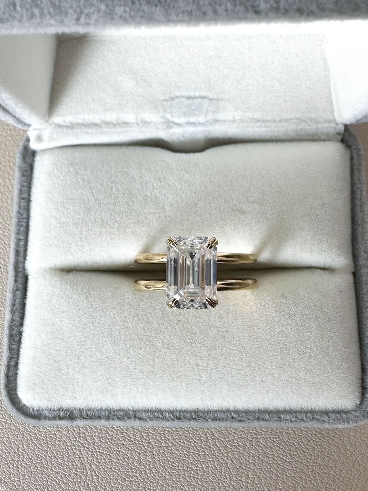 an engagement ring in a box with a diamond on the top and bottom, sitting inside