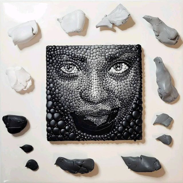 an image of a woman's face made out of black and white paper, surrounded by other pieces of art