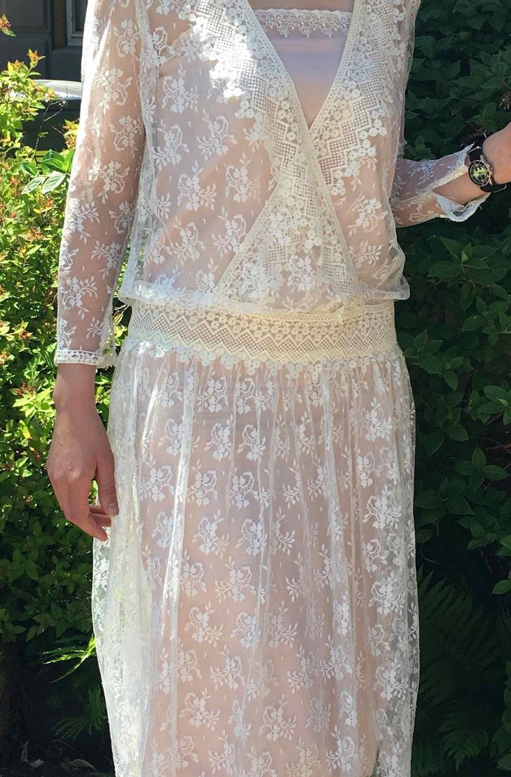 "Lovely Vintage 90's off white lace dress. Sheer see through style. Dare to bare or layer. See that this dress comes with the pink satin lining but we also photographed this with a black slip underneath. (Black slip not included). Measurements for Outer Lace Dress: 14\" Arm 14\" Shoulders 34\" Waist 49\" Length Measurements for Pink Satin Lining: 32\" Bust and Waist 49\" Length" Feminine Lace Top Wedding Dresses, Wedding Night Lace Patchwork Dress, Fitted Delicate Dresses With Scalloped Lace, Sheer Fitted Summer Lace, Fitted Sheer Lace For Wedding Night, Delicate Fitted Scalloped Lace Dresses, White Lace Trim Dress For Wedding Guest, Elegant Sheer Lace For Summer, Spring Wedding Embroidered Lace Dress