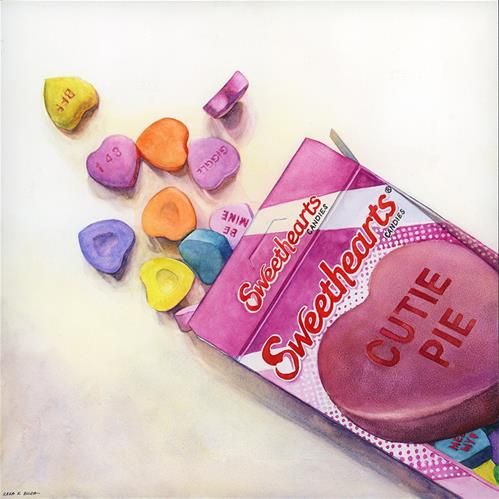 a candy box with conversation hearts on it next to other candies that have been cut in half