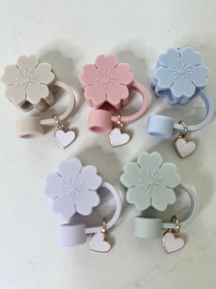 six different colored flower shaped rings with hearts on each one and a heart in the middle