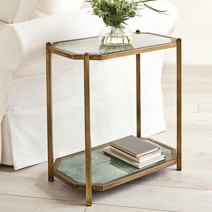 a glass and metal end table with a flower in a vase sitting on top of it