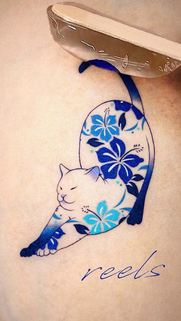 a blue and white cat tattoo on the back of a woman's stomach