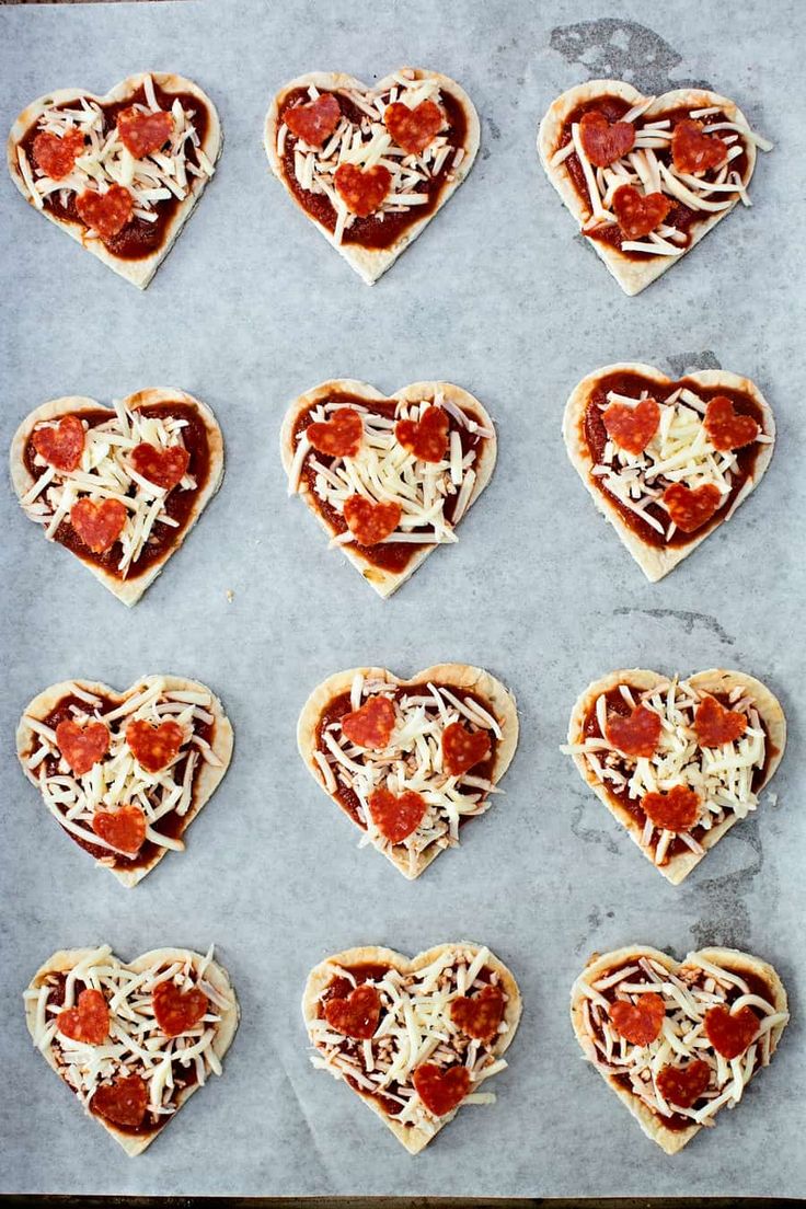 heart shaped pizzas are arranged on a baking sheet