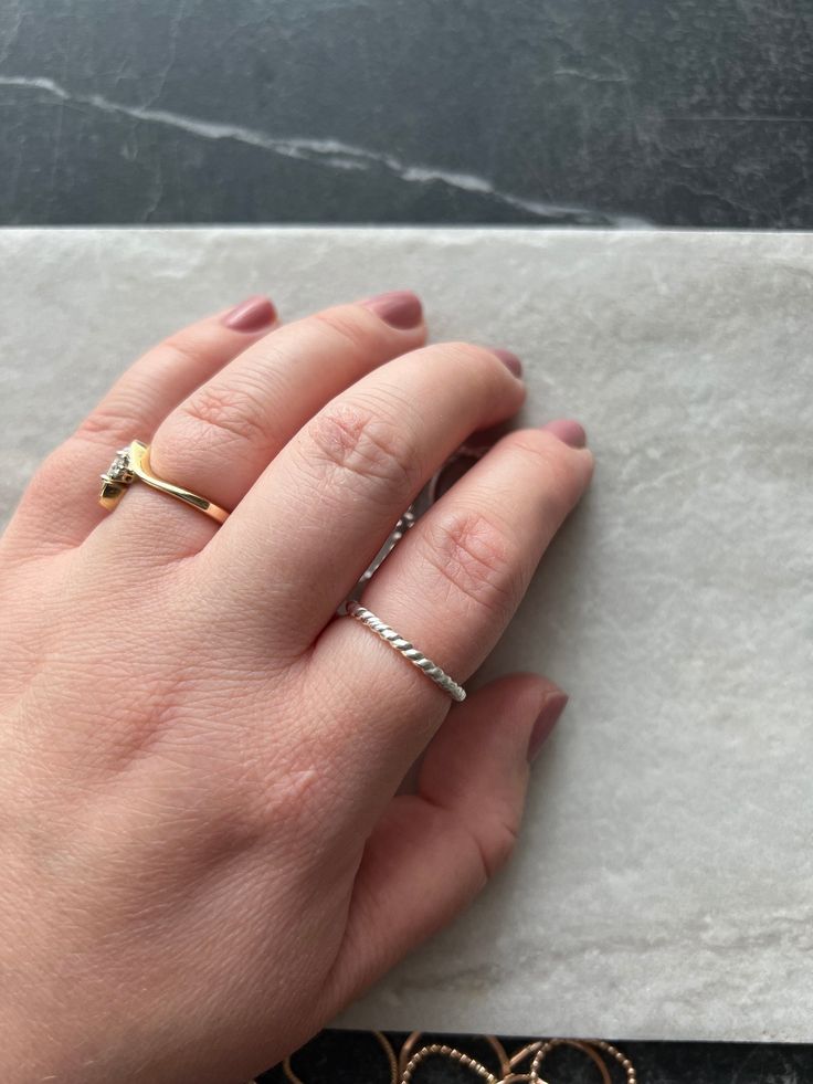 This twist dainty band is a must for any ring collection. It is simple yet stunning. Wear it on it's own or stacked with some simple bands. size Inclusive! available in sizes 3-15. note this lyric is soldered closed! Made with 14k gold, or sterling.  Hypoallergenic, the hand-shaped ring is made with high quality 14k gold fill metal that is the ideal solution for sensitive skin and will last for years to come. Gold-fill material contains 100x more gold than the microscopic film found on gold plated material. You can wear your gold-fill jewelry daily without having to worry about it losing its shine, chipping, or flaking. Each item is handmade and made to order, so please allow for slight variation. Orders typically ship within 7-10 business days. PLEASE CONTACT ME  prior to purchase if your Hand Shaped Ring, Dainty Band, Simple Band, Stacking Bands, Ring Collection, Fall Shopping, Gold Filled Jewelry, Ring Collections, Bracelet Gift