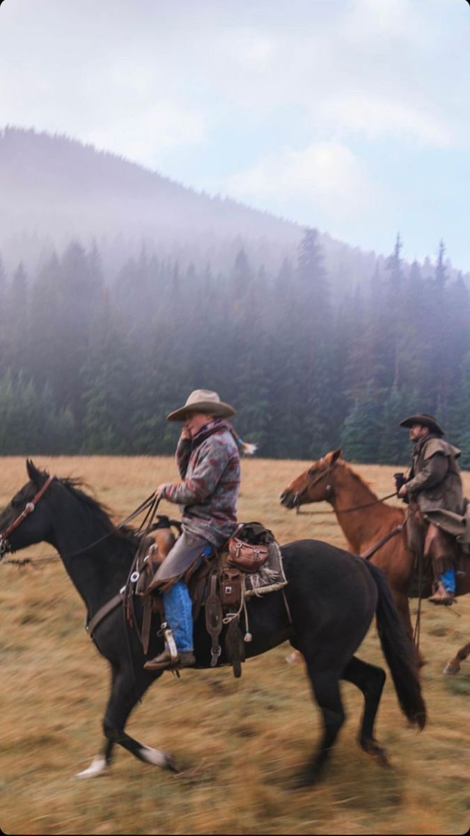 two men are riding horses in a field