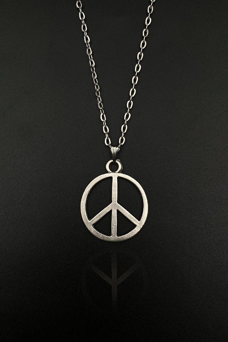 Step into a world of tranquility and serenity with our Peace Sign Necklace. This beautifully handcrafted necklace is perfect for both men and women, embodying the universal symbol of peace in a stylish and elegant manner. Whether you're a lover of all things boho or a dedicated follower of the hippie culture, our Peace Symbol Necklace is designed to resonate with your unique spirit and style. Embrace peace, radiate love, and express your unique style with our Peace Sign Necklace. This isn't just Everyday Symbolic Handmade Charm Necklaces, Bohemian Peace Sign Necklace For Gift, Hippie Style Necklace With Round Pendant For Gift, Vintage Jewelry With Peace Sign As Gift, Symbolic Peace Sign Jewelry For Gift, Vintage Jewelry With Peace Sign For Gift, Symbolic Silver Jewelry With Peace Sign, Adjustable Peace Sign Necklace As Gift, Adjustable Peace Sign Necklace