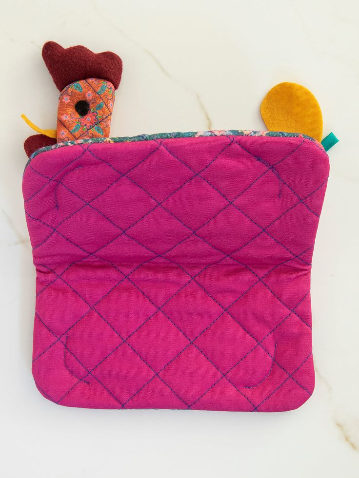 a pink pouch with a chicken on it and a small toy in the back pocket