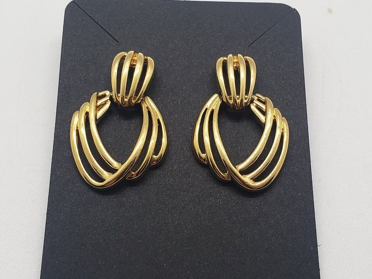 This style feels vintage, yet never dated. From legendary costume jewelry designer Monet. These gold colored wire earrings dangle freely. One of these studs has a slight wiggle. These earrings are for pierced ears.  Length  1.5" Width  1"  This item is vintage and has been pre-loved. As such it may show signs of wear and aging. Please see pictures for details. Vintage Gold-tone Earrings For Evening, Vintage Gold-tone Evening Earrings, Retro Gold Earrings For Evening, Retro Gold Evening Earrings, Retro Gold Drop Clip-on Earrings, Vintage Gold Hoop Earrings For Evening, Retro Gold Dangle Earrings, Retro Gold Dangle Clip-on Earrings, Retro Metal Earrings For Evening