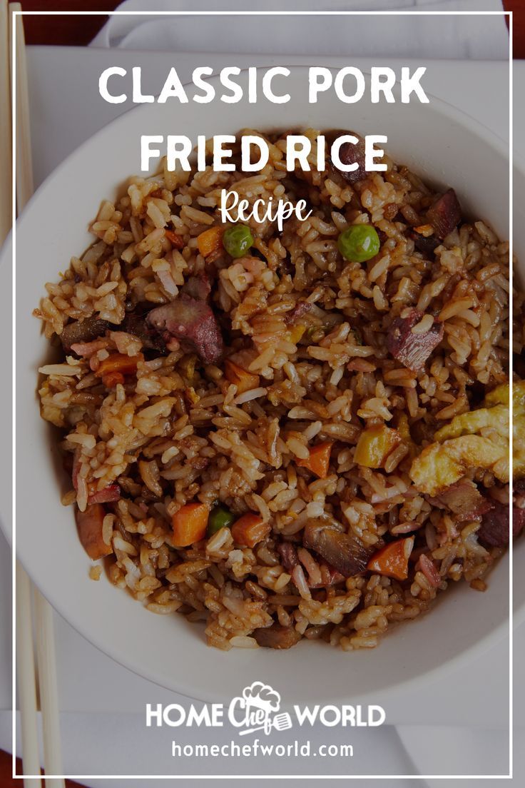 a white bowl filled with fried rice and vegetables next to chopsticks on a table