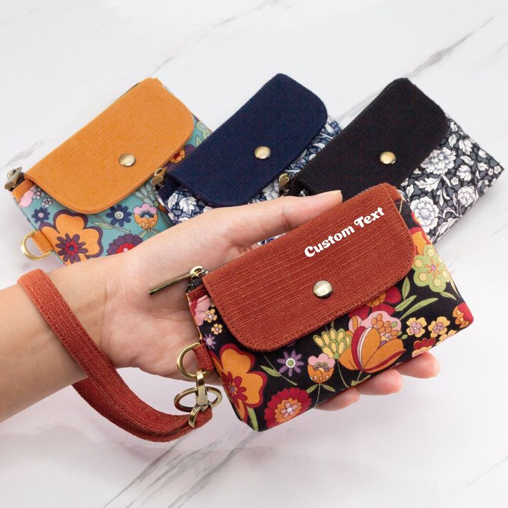 a woman holding four different colored purses in her hand on a marble countertop