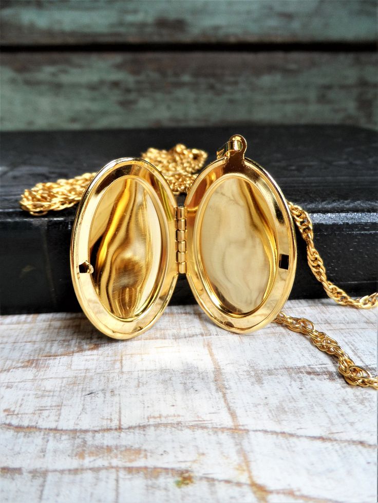 This is a vintage 1960s double chain locket necklace, marked Park Lane on a metal tag. It is a gold tone metal. There is one short chain and one long chain. The shortest chain is 16 in., and the longest chain is 24 in. long. The oval locket is 1 3/4 in. long, and 1 1/8 in. wide, without the bail. The necklace is in great condition. Thank you for looking! Gold-tone Locket Chain Necklace As Gift, Gold-tone Chain Necklace With Locket For Gift, Gold Brass Locket Chain Necklace, Gold Brass Chain Necklace With Locket, Gold Metal Locket Necklace With Vintage Charm, Gold Locket Necklace With Adjustable Chain, Vintage Gold Medallion Necklace With Chain, Antique Gold Metal Locket Necklace, Vintage Gold-tone Medallion Necklace For Gift