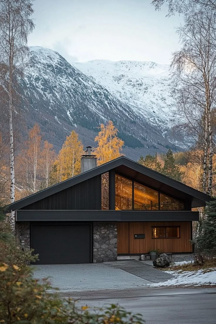 a house in the woods with mountains in the background