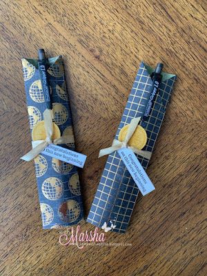 two wrapped candy bars sitting on top of a wooden table covered in blue wrapping paper