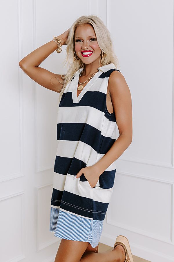 - Sail into the sunset in this nautical cutie! With a striped print and a sleeveless cut, it is a perfect piece of classic seaside style. You are sure to make a stylish splash with this charming dress. - Unlined striped material with blue and white hued accent trim at the bottom - A collared v-cut neckline - A sleeveless cut - Functional side pockets - A relaxed silhouette that ends in a straight mini dress length hemline Nautical Cotton Summer Dress, Nautical Style Summer Vacation Dresses, Nautical Dresses For Summer Vacation, White Sleeveless Nautical Dress, Chic Sleeveless Dress With Striped Hem, Nautical Sleeveless Beach Dress, Nautical Sleeveless Dresses For The Beach, Cotton Nautical Sleeveless Dress, Nautical Spring Vacation Dresses