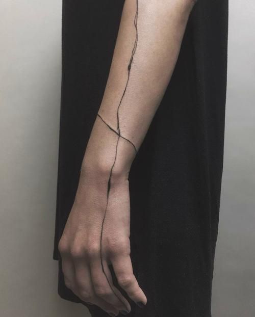 a woman's arm with a vine tattoo on it