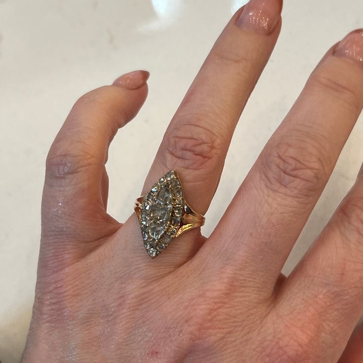 a woman's hand with a ring on it and a diamond in the middle