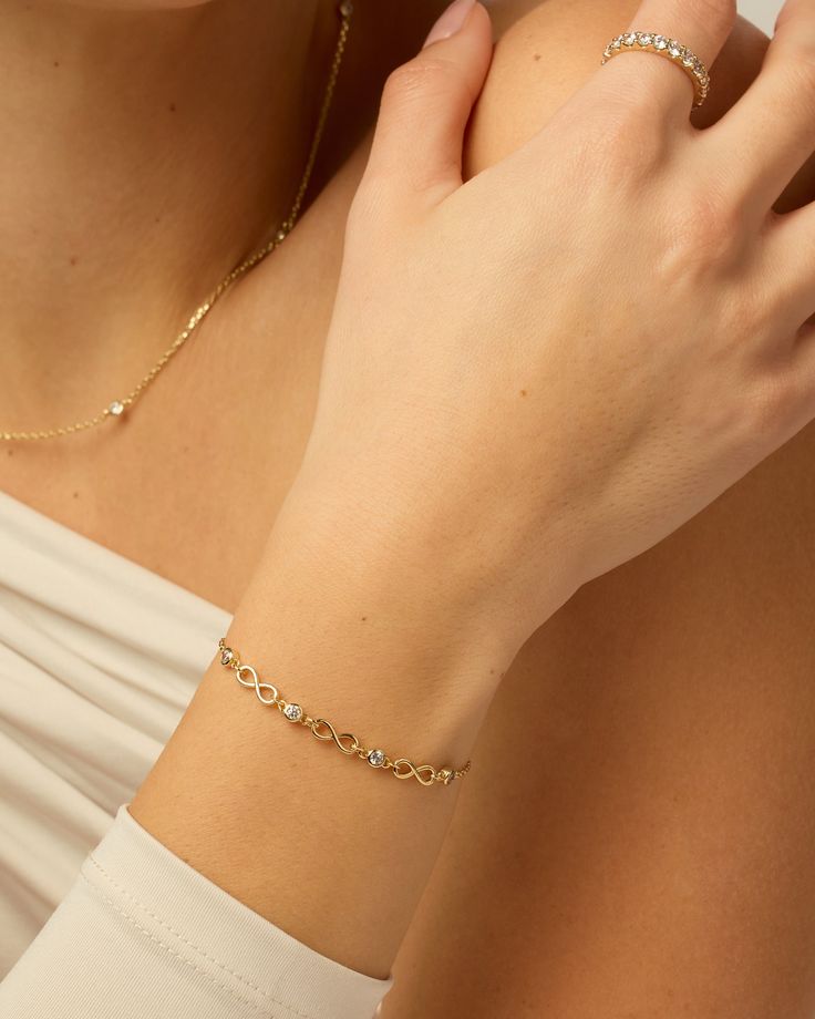 Get our Endless Love Infinity Bracelet to express your eternal love. It features a delicate chain and a charming infinity symbol, perfect for gifting on special occasions like birthdays and anniversaries.Materials: 14K Yellow Gold or Rhodium plated. AAAAA Cubic Zirconia. Measurements: Length: 6" + 2.5" extender; Chain Width: 1.2mm; Charms Width: 3.8mm; Infinity Charm: 10mm x 3.8mm. Hypoallergenic; nickel, lead, and cadmium free. Infinity Chain, Infinity Bracelet Gold, Elegant Infinity Chain Bracelet Gift, Elegant Gold Infinity Bracelet As Gift, Gold Infinity Jubilee Bracelet, Elegant Gold Infinity Bracelet For Gift, Adjustable Gold Infinity Chain Bracelet, Gold Bracelet Simple, Infinity Charm