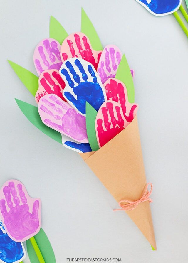 paper flowers with hand prints on them are shown