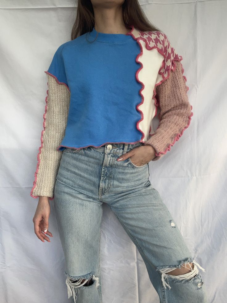 a woman wearing ripped jeans and a blue top