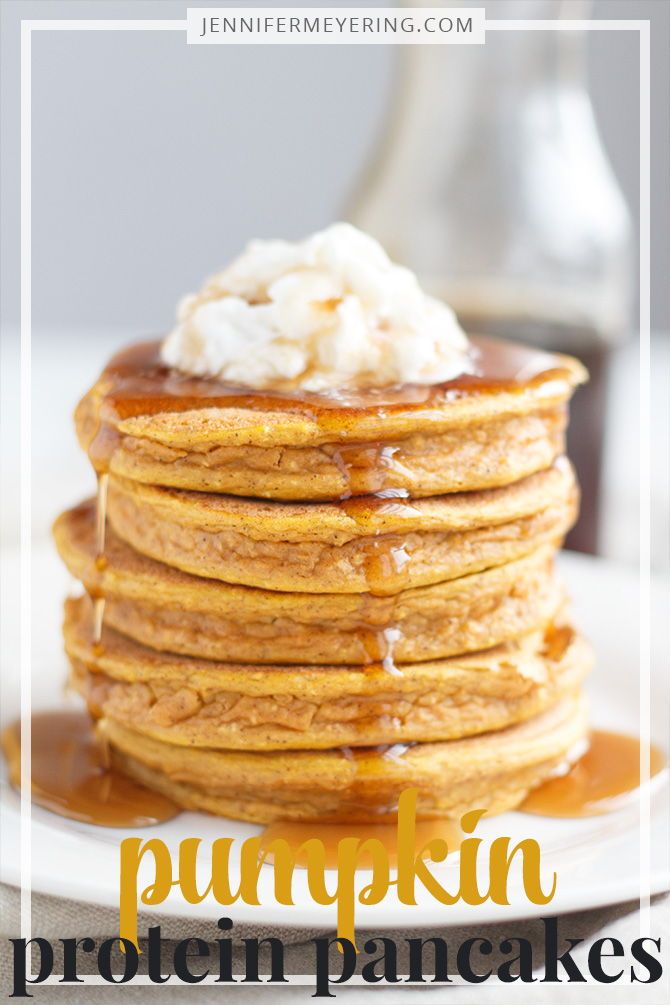 stack of pancakes covered in syrup and whipped cream