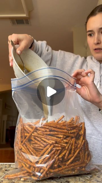 a woman pouring something into a bag with pretzels in it on the counter