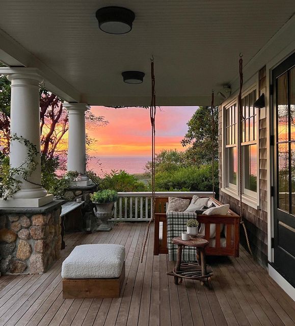 a porch with a bench and chairs on it