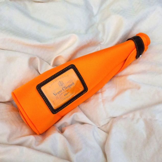 an orange umbrella laying on top of a bed